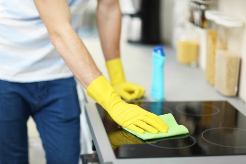 Cleaner treating a fabric sofa during sofa cleaning in W1